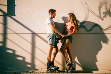 couple in love on the rollers near the stairs on the street