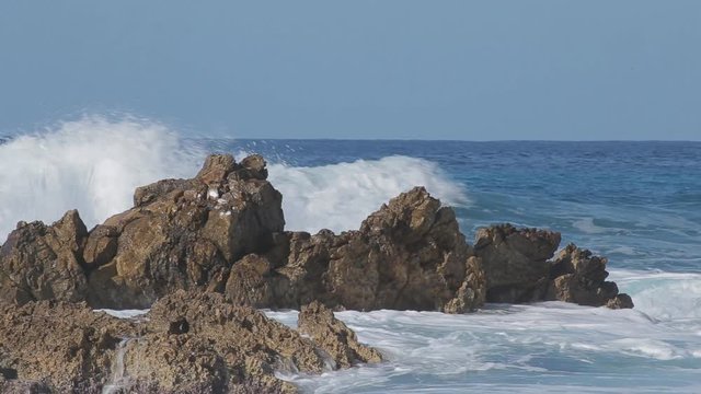 Sea wave beats on a big stone. Sunny day