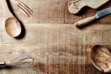 Assorted wooden kitchen utensils on a rustic wooden surface