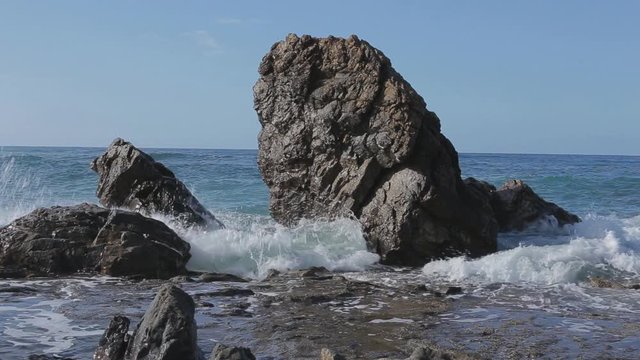 Sea wave beats on a big stones. Sunny day