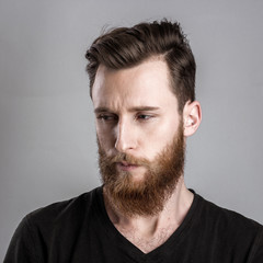 Obraz premium Unconfident and worried young man isolated on gray background