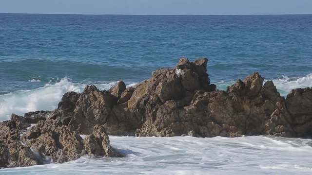 Sea wave beats on a big stones. Sunny day