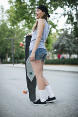 Young woman riding on her longboard.