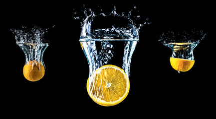Composition of three oranges falling into water close-up, macro, splash water, bubbles, isolated, black background. Big large size.