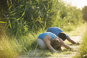 Fototapeta na wymiar Young couple practicing yoga together in a natural background.