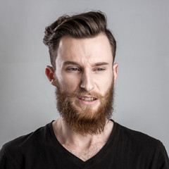 Shocked and worried young man isolated on gray backround