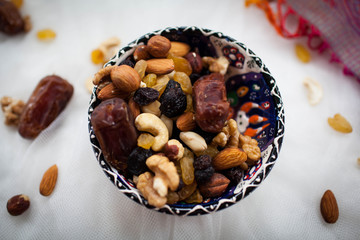 plate with nuts and dried fruits lying on a white table