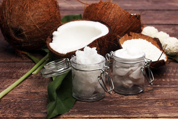 Coconut with leaves and coconut oil in jar
