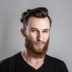 Obraz premium Treacherous and crafty young man isolated on gray background