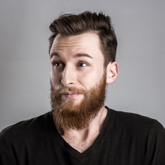 Fototapeta premium Unconfident and worried young man isolated on gray background