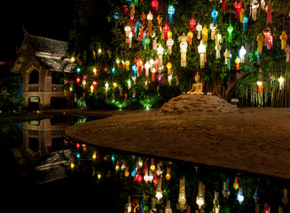 Colourful lanterns above Buddha statue. Loy Krathong festival decorations and a small Buddha statue...