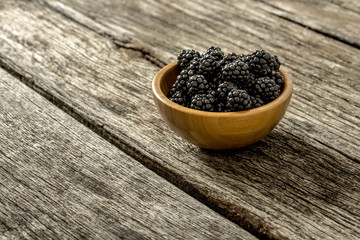 Fototapeta na wymiar Blackberries in a wooden bowl