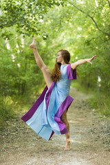 Happy girl. Young woman dancing on the meadow