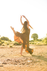 Happy girl. Young woman dancing on the meadow
