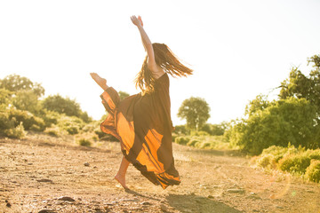 Happy girl. Young woman dancing on the meadow