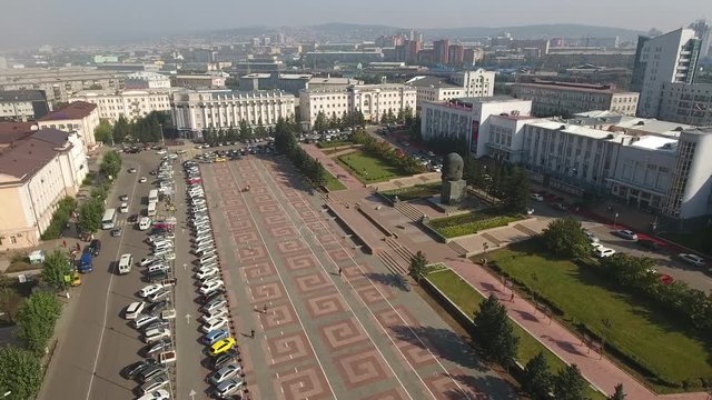 Central Council square. Monument Lenin Greatest bronze sculpture of head Lenin. Ulan-Ude Russia Soviet buildings. Summer blue sky. Aerial Drone flight General plan high altitude span over an area 4k