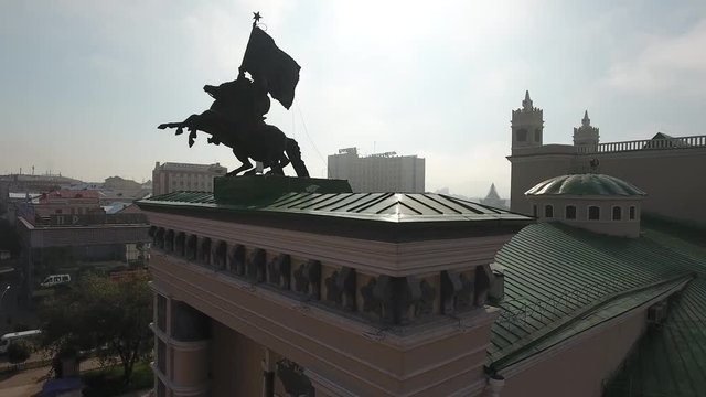 Buryat State Academic Opera and Ballet Theater Russia Siberia Buryatia Ulan-Ude. Сentral square Monument of horse man with flag on the roof Sunny summer Close-up around monument Flight Aerial Drone 4k