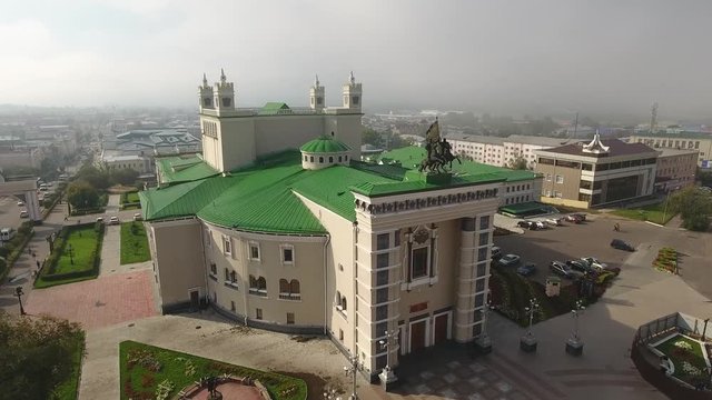 Buryat State Academic Opera Ballet Theater Russia Siberia Buryatia Ulan-Ude Сentral square Monument horse man with flag People walk Arch. Sunny summer blue sky Approach to building large Flight Aerial