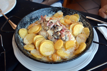 Traditional Portuguese food. Codfish with mushroom sauce served on a traditional casserole.