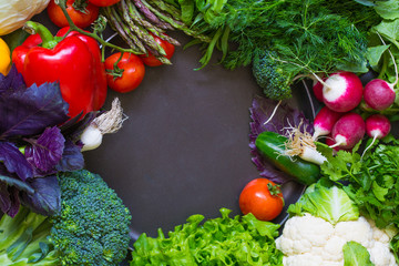 Fresh spring vegetables on black chalkboard