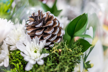 Bouquet with white pine cone and flowers wrapped in plastic