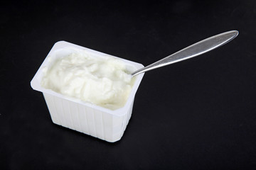 Ein Becher Quark mit Löffel