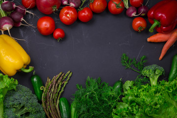 Fresh spring colorful vegetables on black chalkboard
