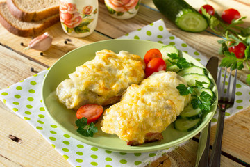 Pork steak with potatoes, grated cheese on a plate with fresh vegetables.