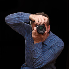 The photographer takes a picture by pointing the camera at the viewer