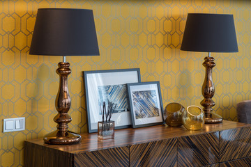  Chest of drawers. Decor with lamps and pictures in modern interior.