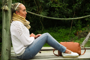 Beautiful young contemplative woman sitting staring at nature