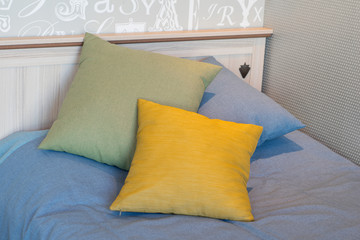 Three pillows. Yelow, green, blue.
