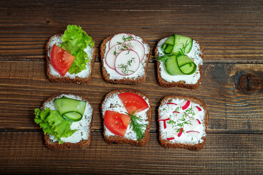 Canapes with cucumber, radish and tomato. Different types of sandwiches. The concept of food and vegetarianism.