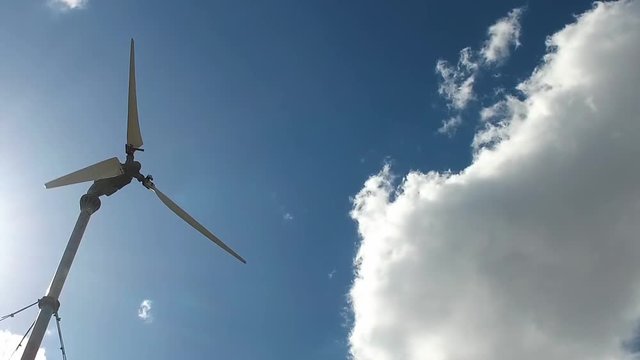 Wind generator closeup on blue sky background with big cloud. Slow Mo. Kostanay, Kazakhstan. 2017.