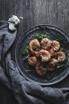Overhead view of garlic shrimps served in plate on wooden table