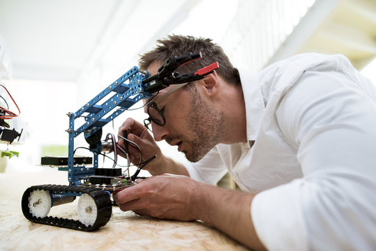 Engineer examining drone at table in office