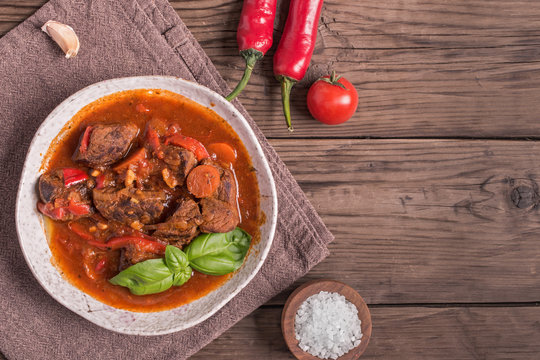 Bowl of goulash on rustic wooden  background. Traditional hungarian meal,  beef stew. Toned. Copy space