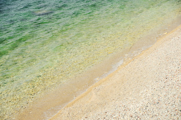 Soft wave of the sea on a sand and pebble beach