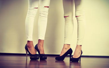 Two women legs presenting high heels