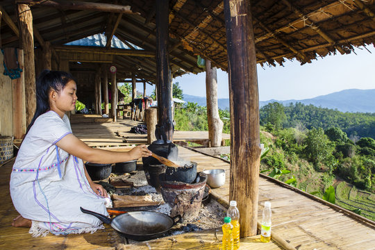 Asian woman cooking on patio outdoors