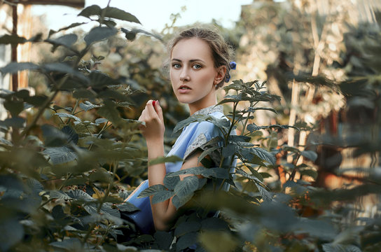 Young woman standing among bushes