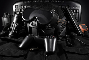 Tactical helmet, gloves, gun, binoculars laying on a jacket with gamepad & keyboard on background.