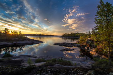 Rocky shore. Sunrise. Beautiful clouds over the water. Karelia. Ladoga lake.