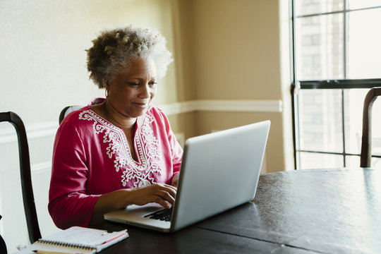 Black woman using laptop at table