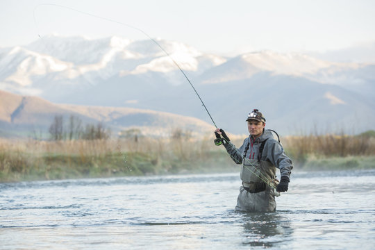 Caucasian man fly fishing in river