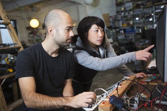 Man and woman working with electronics in workshop