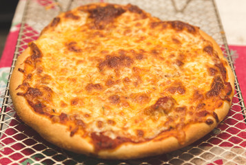 Freshly Baked Pizza Cooling on a Metal Rack