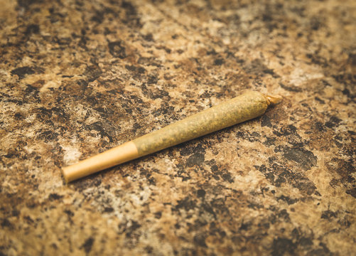 Pre-Rolled Joint on Textured Background