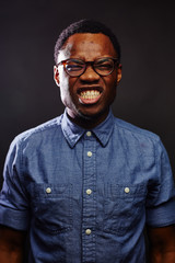 Obraz premium attractive young black male studio dark light gritting teeth silly