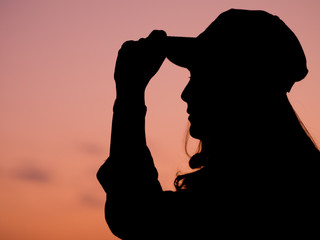 Silhouette of a young woman relaxing on a beautiful sunset.
